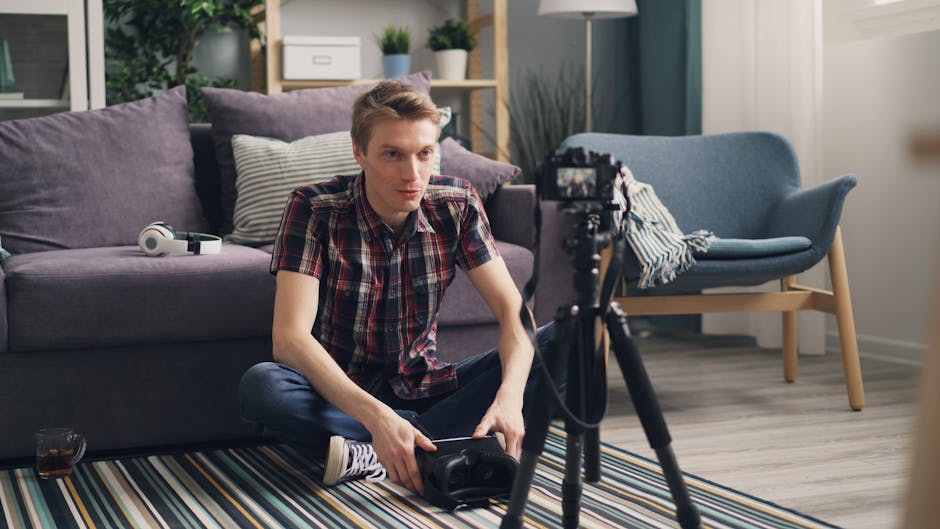 Young man sitting on the floor filming a vlog in a cozy living room with camera and tripod.