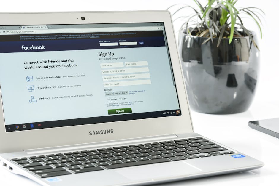 Open Samsung laptop showing Facebook sign-up page next to a potted plant. Ideal for technology themes.