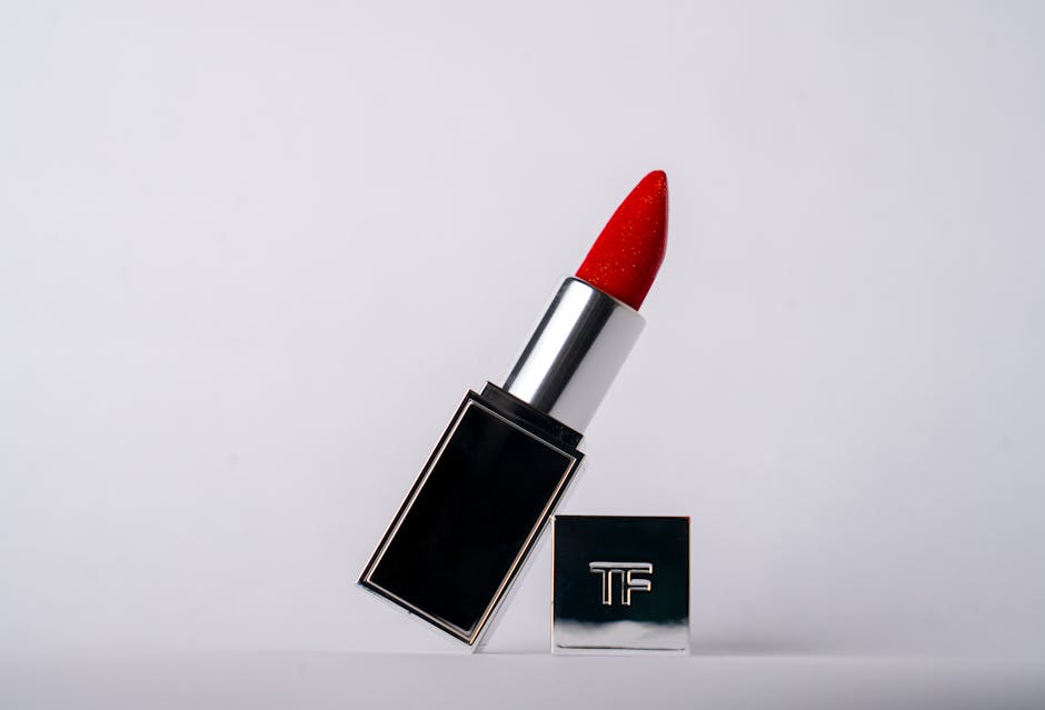 A vibrant red lipstick displayed against a white background, highlighting luxury beauty product design.